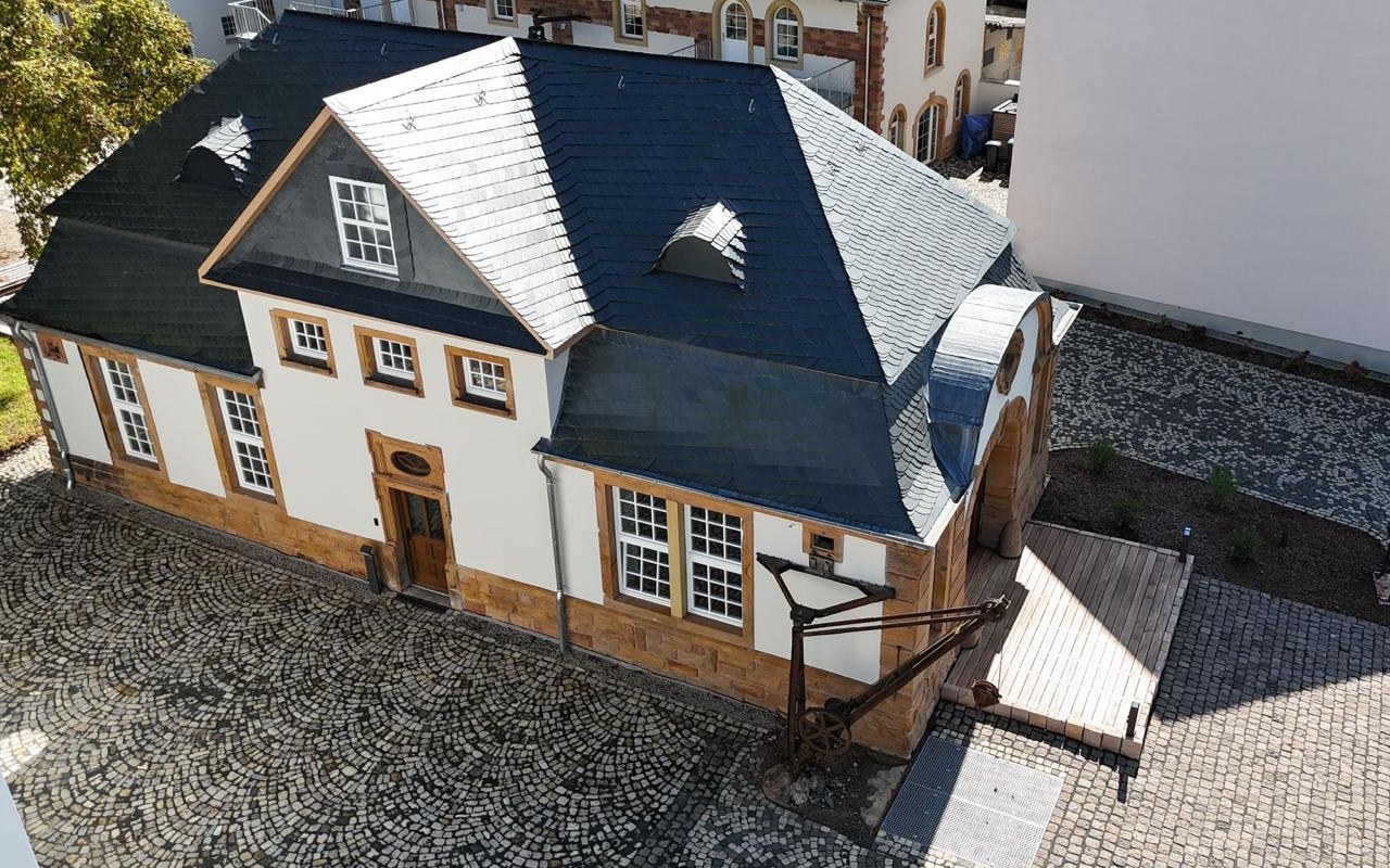 Schieferdach mit Fledermausgaube, Giebelgaube und rundem, schiefergedecktem Anbau